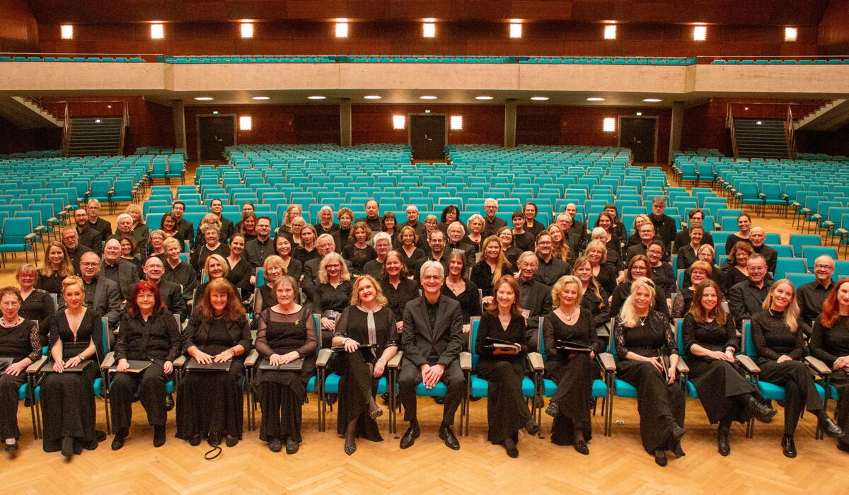 Chormitglieder sitzen auf den Zuschauerplätzen im Parkett der Meistersingerhalle